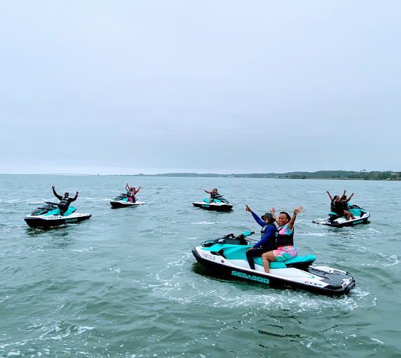 Group of jet ski riders cheering mid-ride on OCA Watersports' 6 Mile Ride