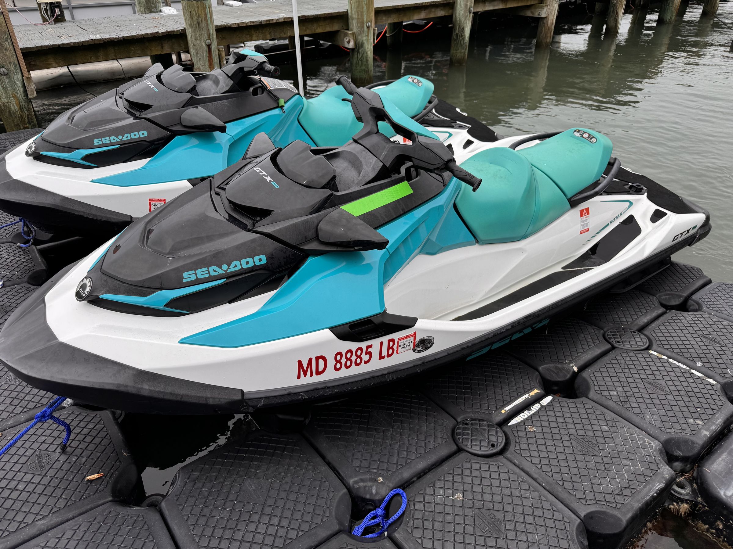 Pair of Sea-Doo GTX Pro 130 fleet skis, side view on the floating dock