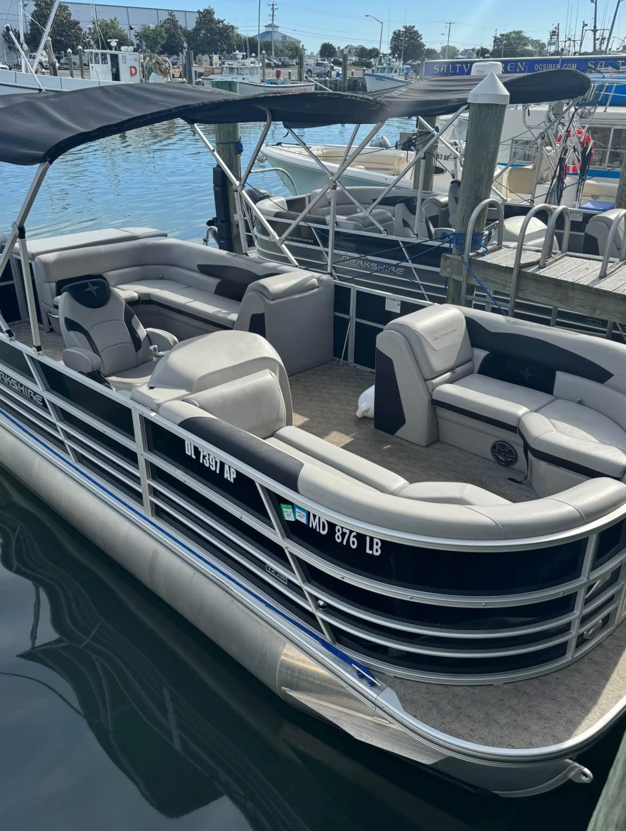 2025 Berkshire 24RFX LE 2.75 tritoon in its slip, bimini up, ready for pick up