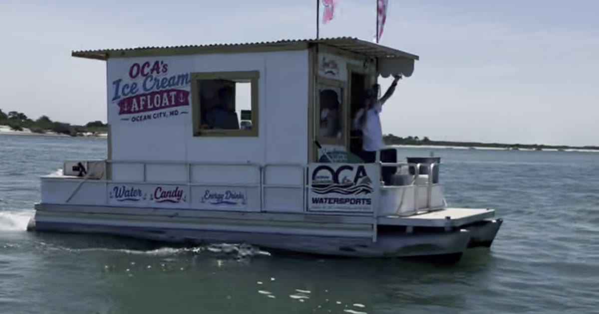 OCA's Ice Cream Afloat pontoon cruising toward the sandbar with the crew waving