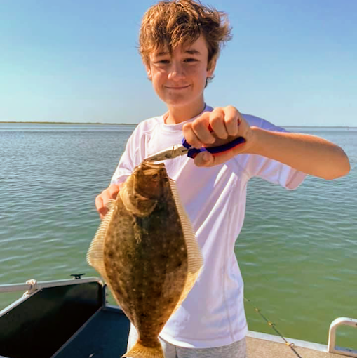 Kid holding up a flounder caught on a pontoon fishing trip in Ocean City MD