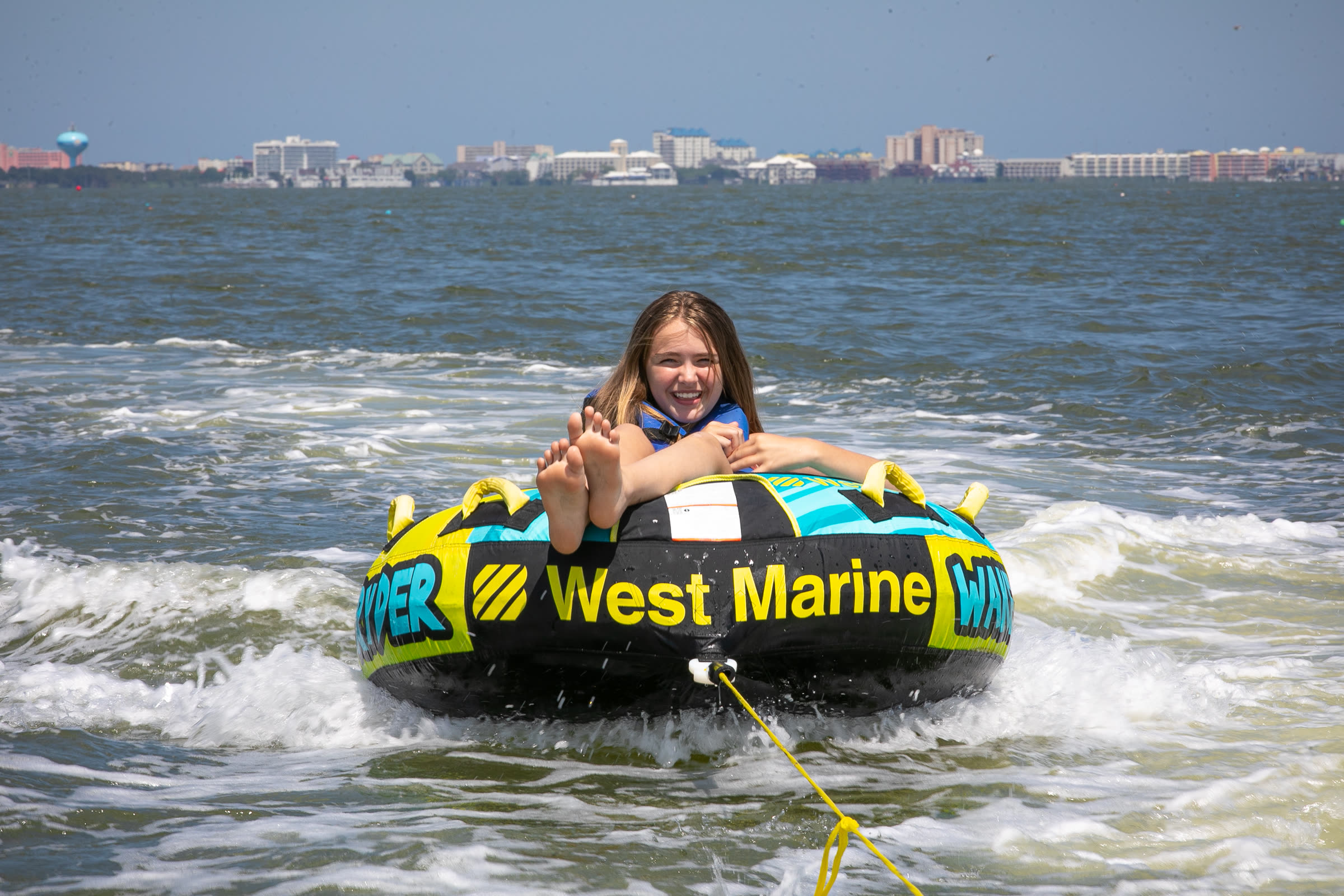 Kid tubing behind a pontoon boat in Ocean City MD